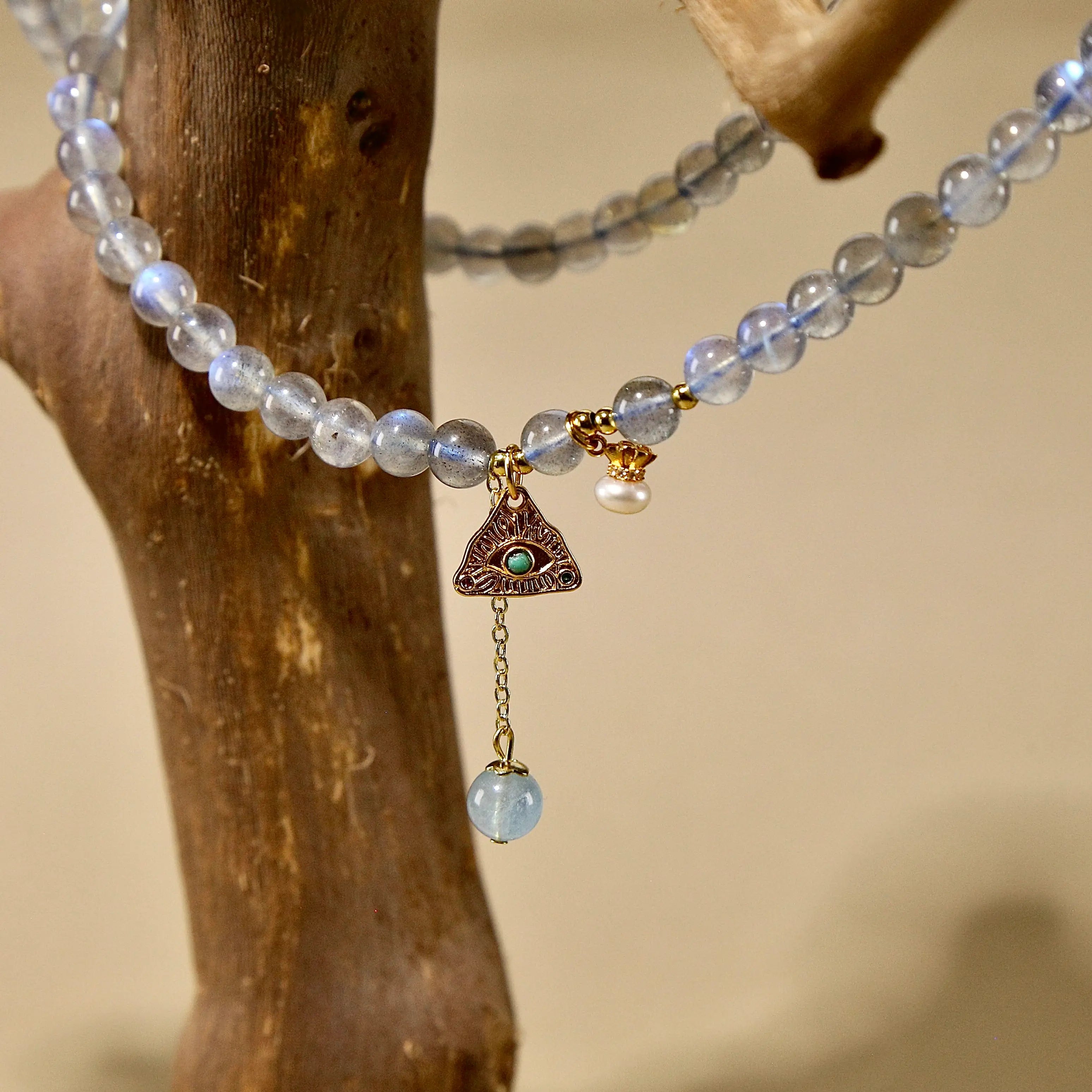 Natural labradorite beaded wrap bracelet featuring a gold triangle charm and small pearl accent.