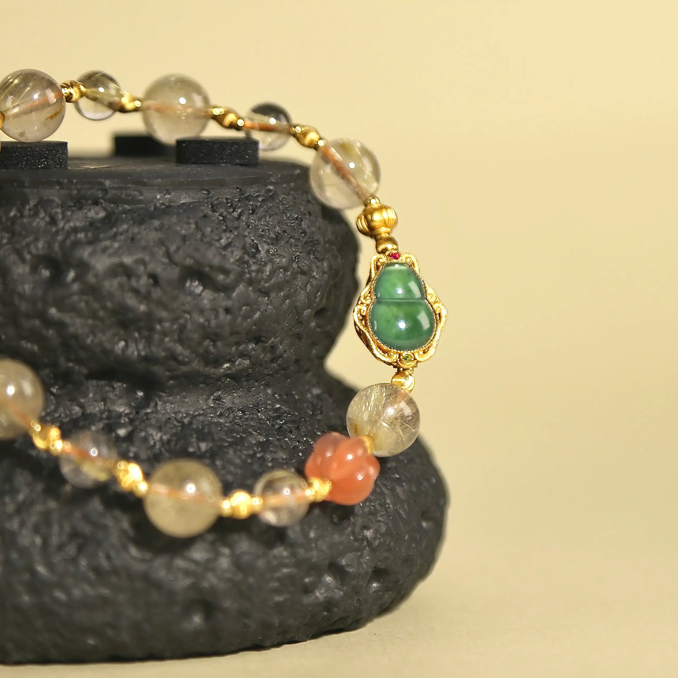 8.5mm Golden Rutilated Quartz bracelet featuring Red Agate and a carved Jade Hulu charm on white background.